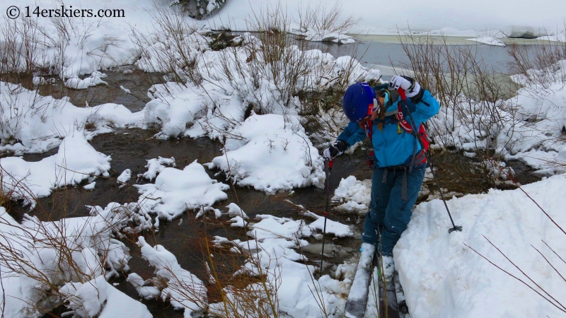 Crossing a stream while backcountry skiing in Crested Butte. 