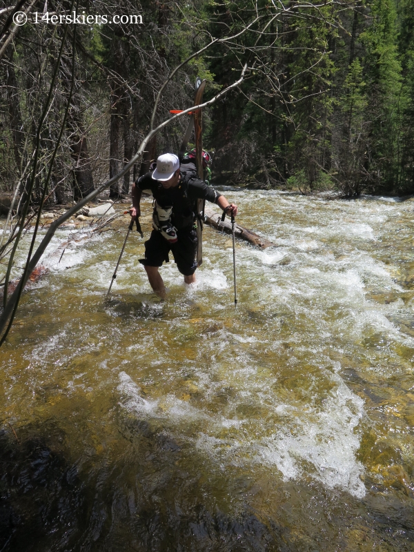 Mark Cavaliero crossing a stream on the way to backcountry ski on Mount Elbert northwest gullies. 