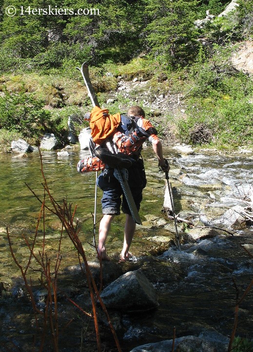 Frank Konsella crossing creek to ski Huron Peak