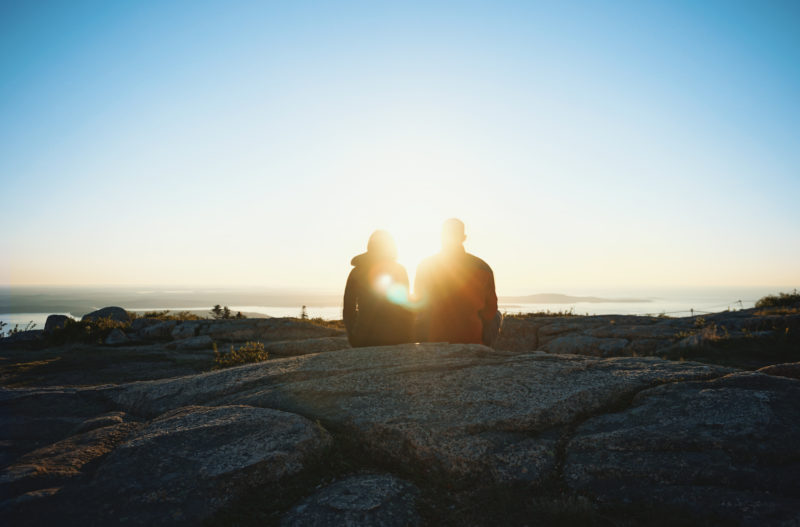 A couple soaks in the views at Acadia National Park. 